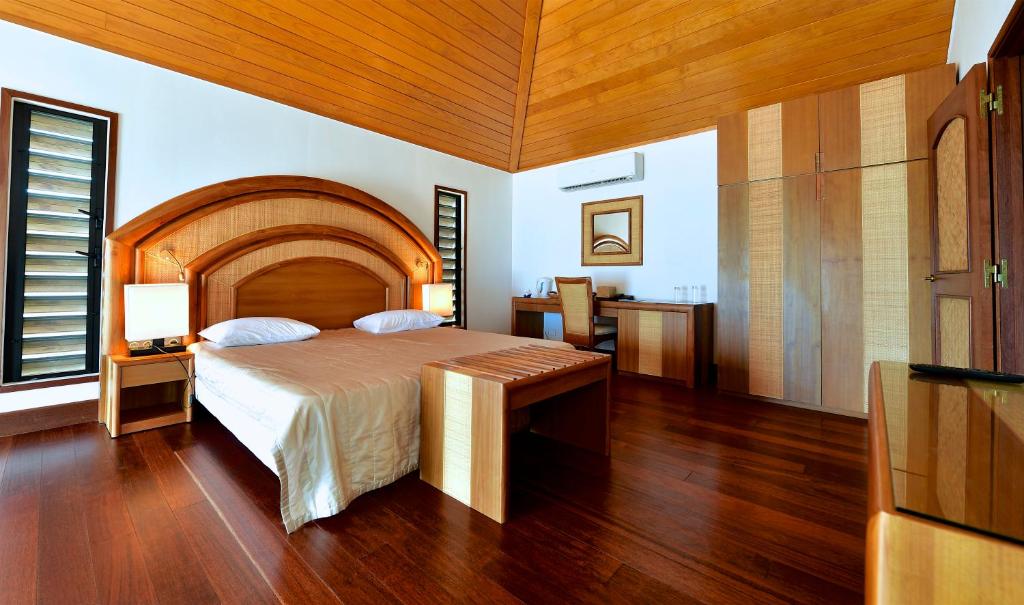 1 dormitorio con 1 cama grande y techo de madera en Hotel Paradis d'Ouvéa, en Fayaoué