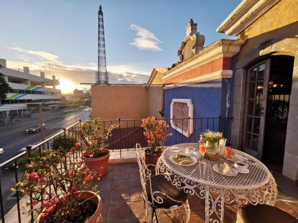 a table on a balcony with a view of a street at Hotel Villa Española in Guatemala