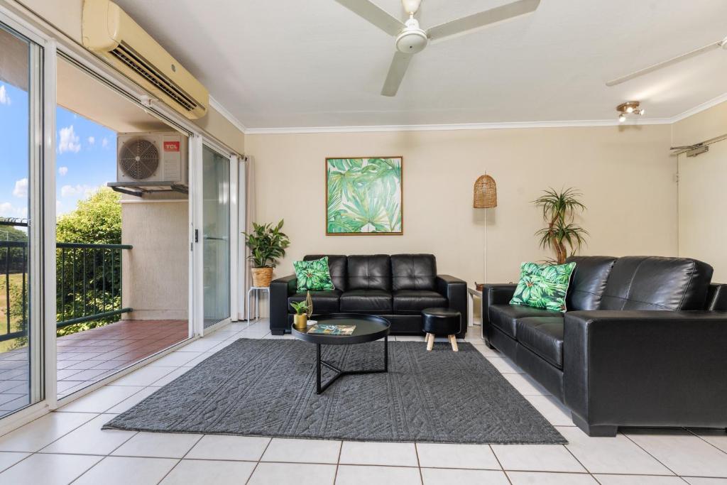 ein Wohnzimmer mit einem Sofa und einem Tisch in der Unterkunft Charming CBD Apt 3bd 2bth - walk to Waterfront in Darwin