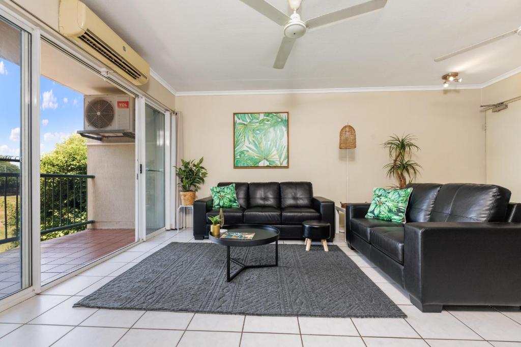 una sala de estar con un sofá y una mesa en Charming CBD Apt 3bd 2bth - walk to Waterfront, en Darwin