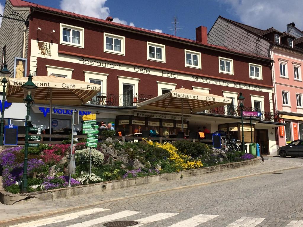 ein Gebäude auf einer Straße mit Blumen davor in der Unterkunft Magnus Klause in Mariazell