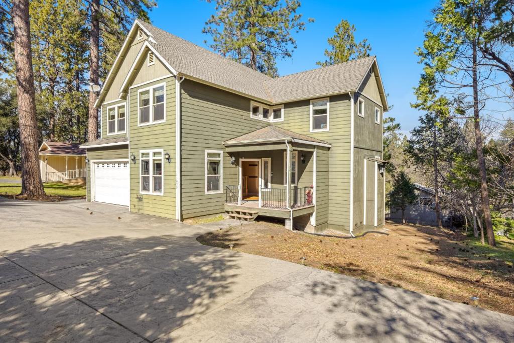 a green house with a porch and a driveway at Sweet Vista in Groveland