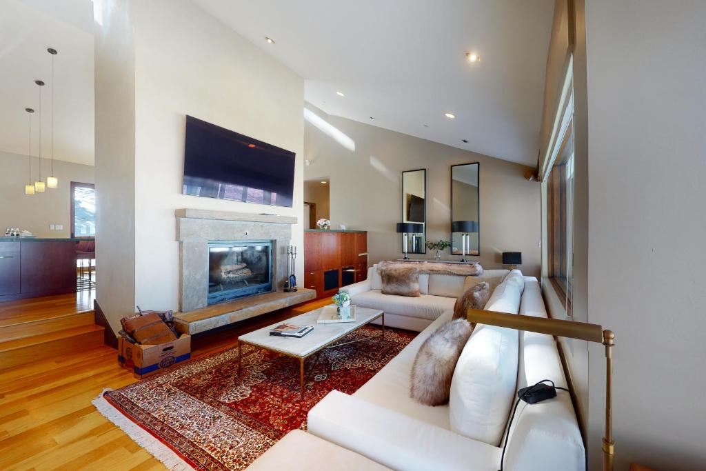 a living room with a white couch and a fireplace at Red Sky Luxury Retreat in Wolcott