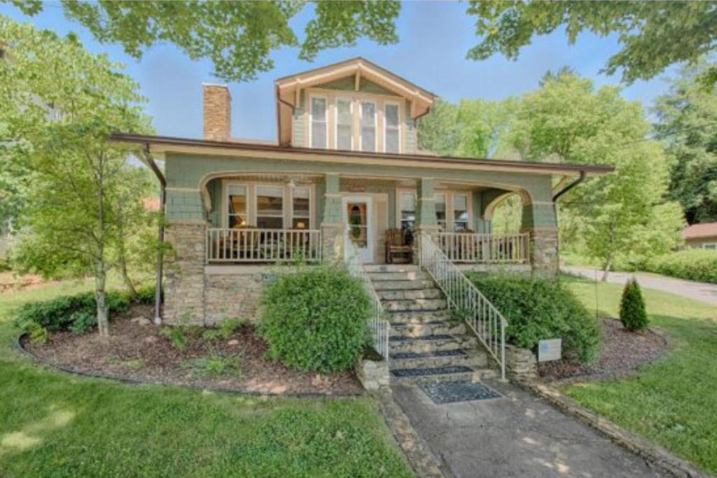 een huis met een veranda en een trap ervoor bij A Beautiful View & Carriage in Lake Junaluska