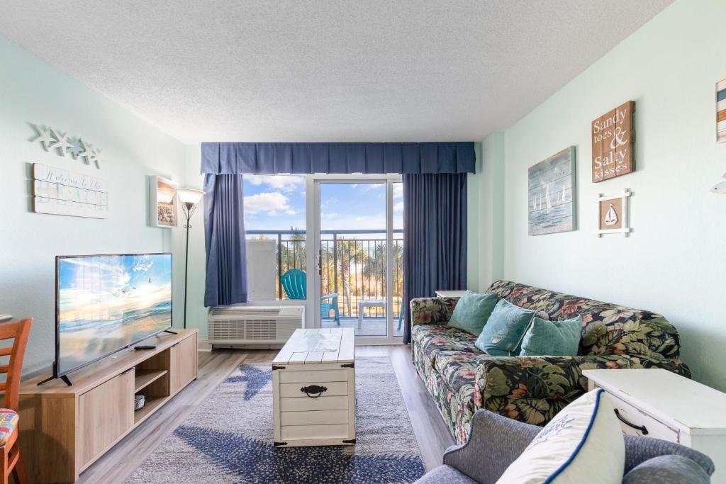uma sala de estar com um sofá e uma televisão em Boardwalk Beach 131 em Myrtle Beach