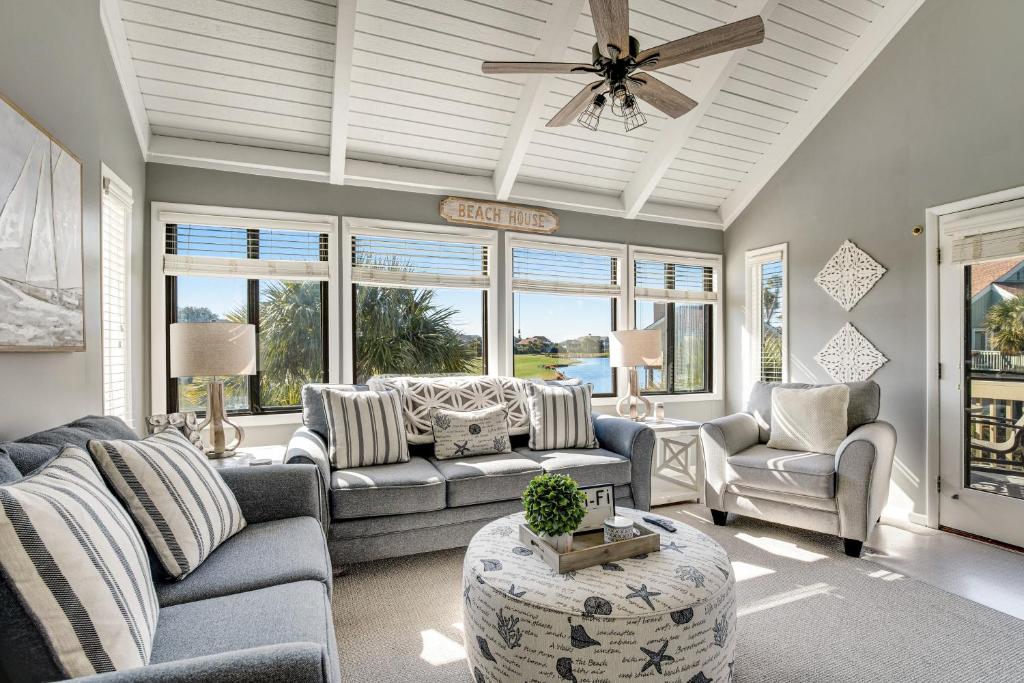 ein Wohnzimmer mit Sofas und einem Deckenventilator in der Unterkunft Sealoft 941 in Seabrook Island