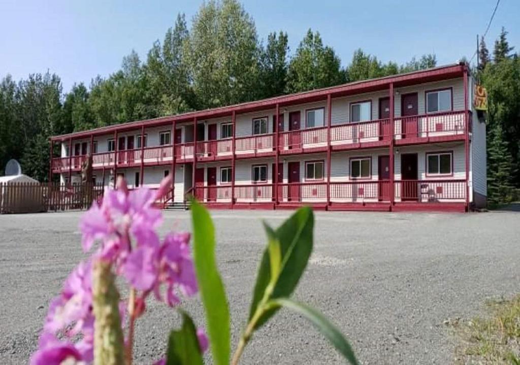 ein großes rotes Gebäude mit vielen Fenstern in der Unterkunft The Place Motel Bar in Kenai