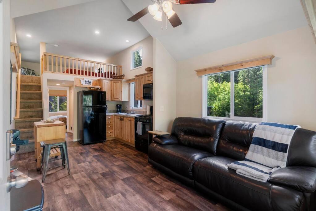 sala de estar con sofá de cuero y cocina en New Tiny Home Steps Away From Mt. Rainier en Ashford