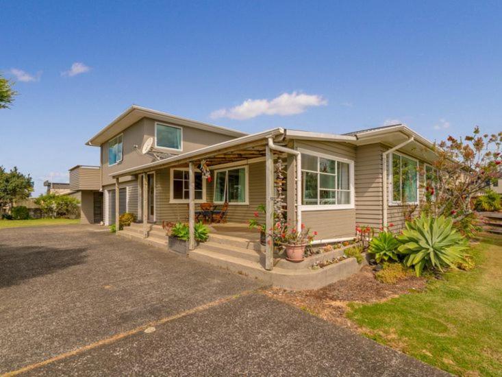 a small house with a porch and a driveway at Hosts on the Coast Views to Mercury in Whitianga