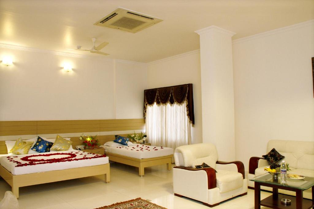 - un salon avec deux lits et une chaise dans l'établissement Hotel DSF Grand Plaza, à Thoothukudi