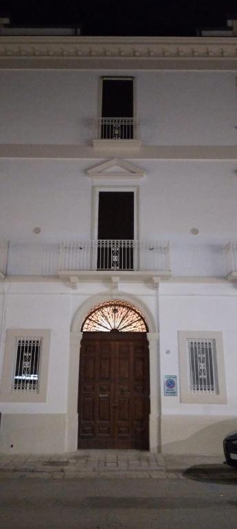 a large white building with a wooden door and a balcony at Dimora Erminia in Polignano a Mare