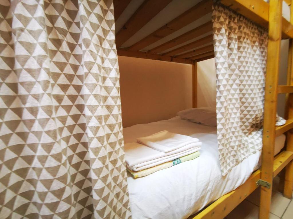 a bunk bed in a room with a curtain at Marseille Hostel in Saint Petersburg