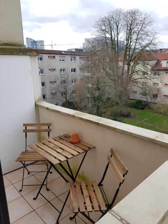 a table and chair on a balcony with a view at Perfect apartment to visit the fair or city in Düsseldorf