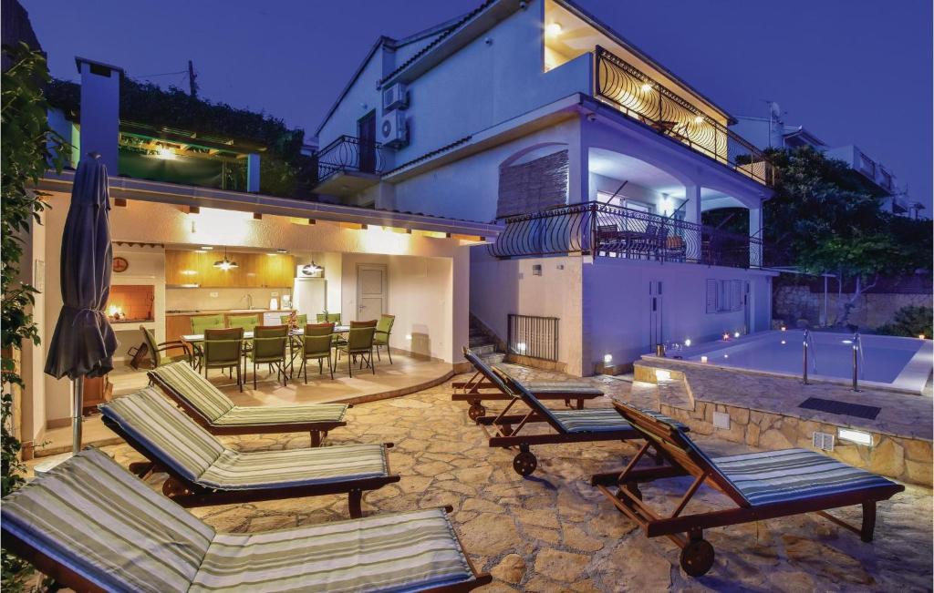 a house with lounge chairs and a swimming pool at Stunning Home In Okrug Gornji With Heated Swimming Pool in Trogir