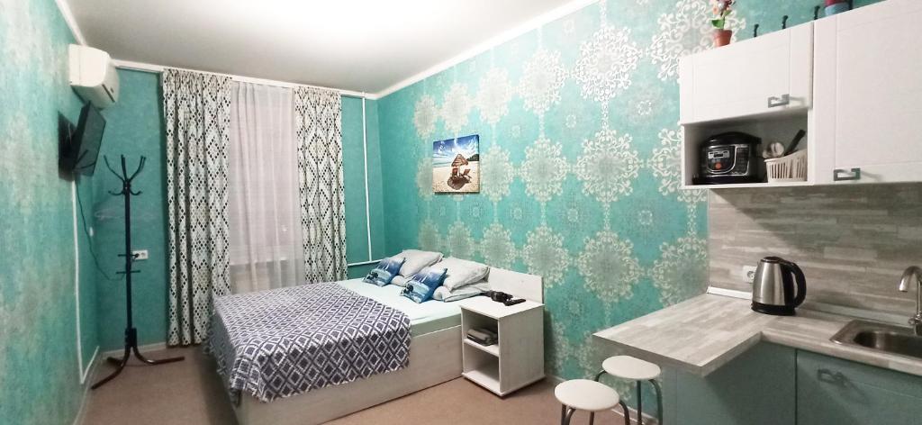 Habitación pequeña con cama y lavamanos en Rent Rooms Barracuda, en Khabarovsk