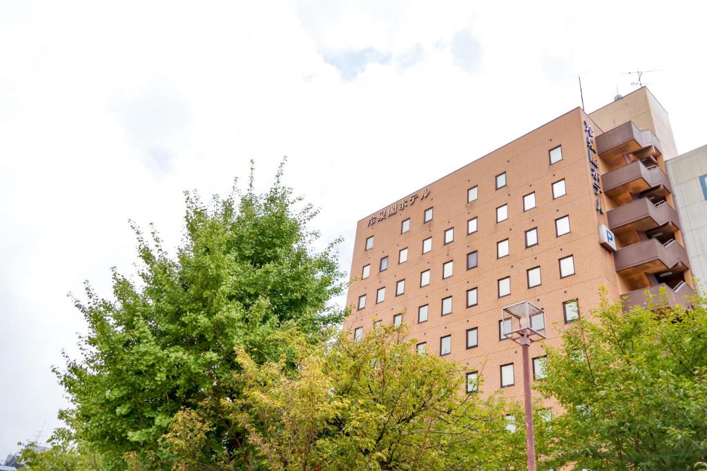 a tall brick building with trees in front of it at Reisenkaku Hotel Kawabata in Fukuoka