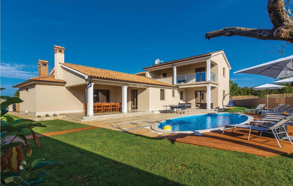 une villa avec une piscine en face d'une maison dans l'établissement Lovely Home In Bibici With Jacuzzi, à Bibići