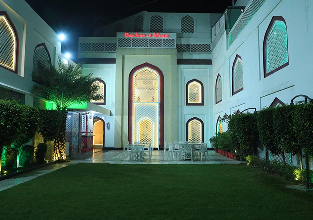 einen Innenhof einer Moschee in der Nacht mit Tischen und Stühlen in der Unterkunft Hotel Darbar-E-Khas A member of Crimson Hotels in Bareilly
