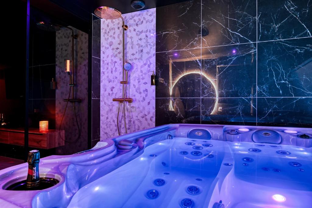 a purple bath tub in a room with a shower at Villa avec jacuzzi privatif in Saint-Cyr-lʼÉcole