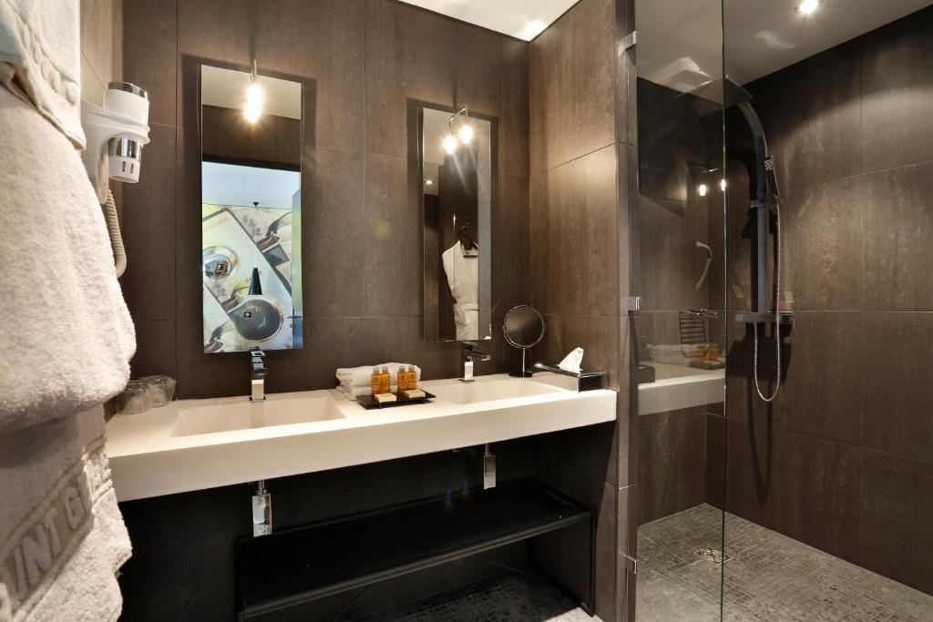 a bathroom with a sink and a shower at Saint Georges Hotel &amp; Spa in Chalon-sur-Saône