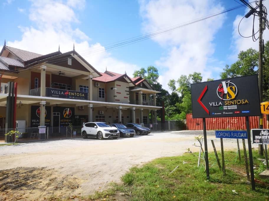 ein Gebäude mit Autos auf einem Parkplatz in der Unterkunft VILLA SENTOSA in Kuala Terengganu