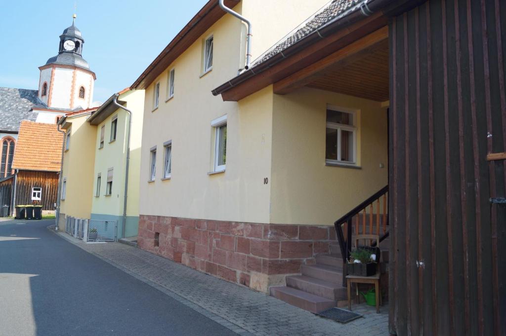 um edifício com uma torre de relógio numa rua em Geißberghaus em Kaltennordheim