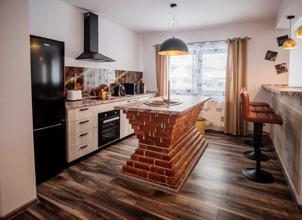 a kitchen with a brick fireplace in the middle at Casa Hugo in Câmpulung Moldovenesc