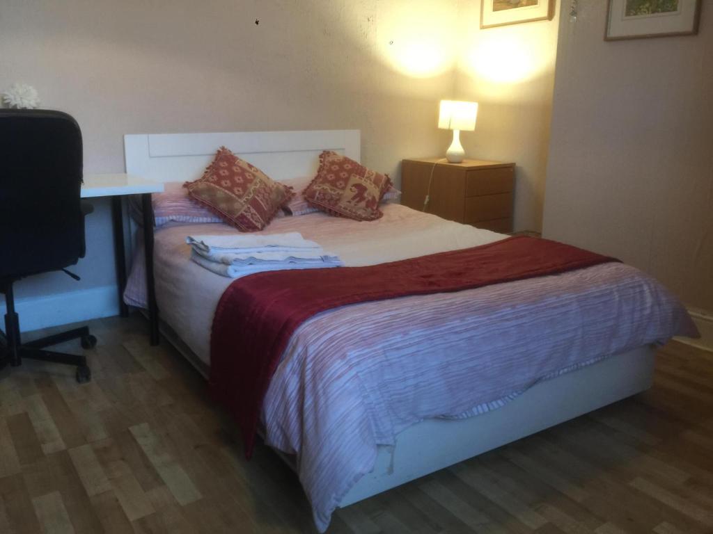 uma cama num quarto com uma secretária e uma cama sidx sidx em DACH Apartments - Cozy 3 bed Apartment in Hendon em Colindale