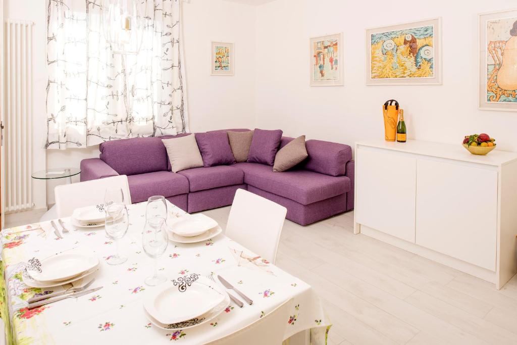 a living room with a purple couch and a table at DALIAHOUSE Bardolino family and cozy apartment in Bardolino