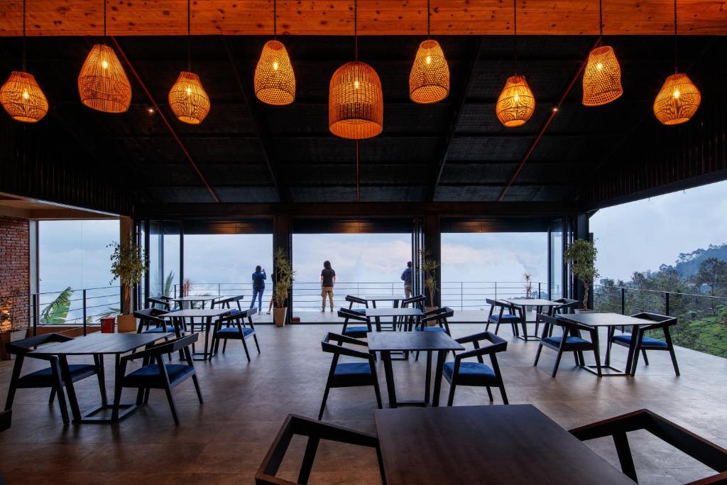 a restaurant with tables and chairs and lights at Vantage hills Haputale in Haputale