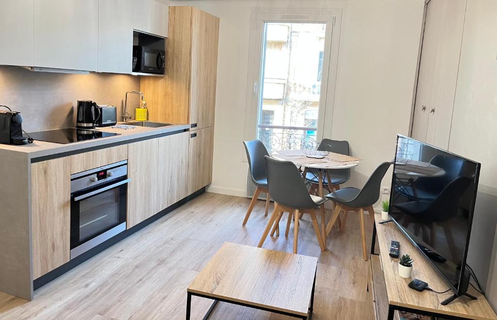 普羅旺斯艾克斯的住宿－L'Aristide，厨房以及带桌椅的用餐室。