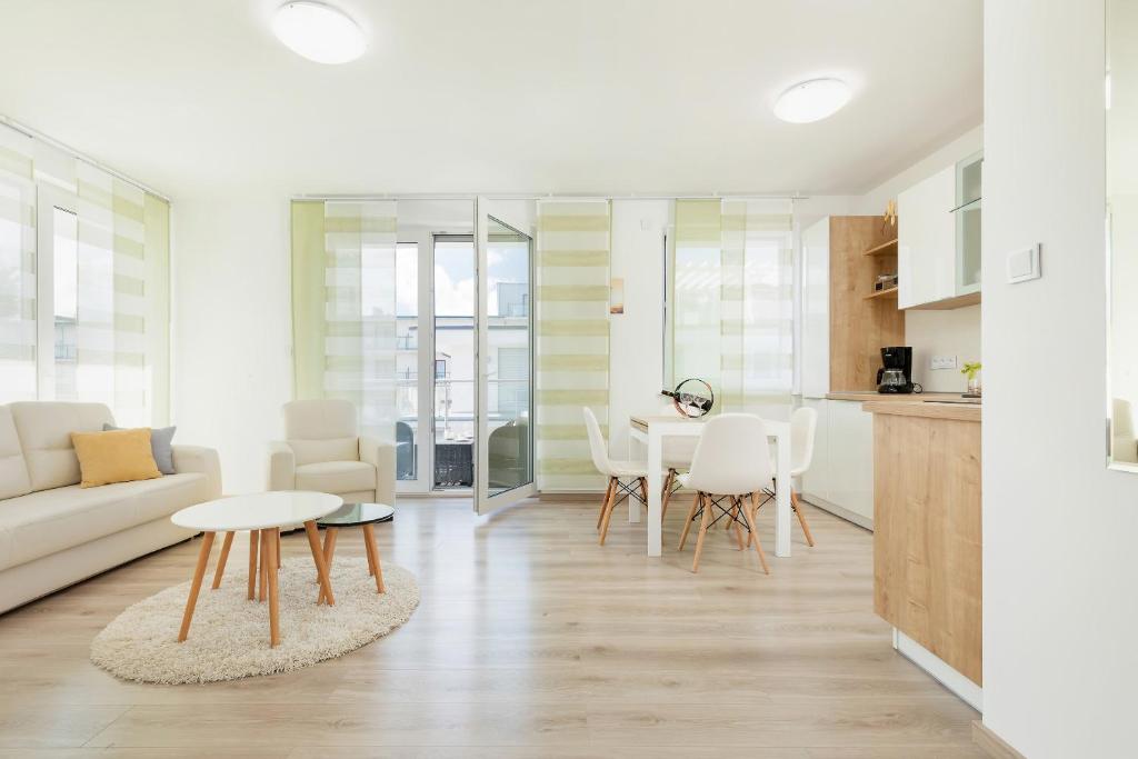 eine Küche und ein Wohnzimmer mit einem Tisch und Stühlen in der Unterkunft Apartament Clara na klifie in Rewal