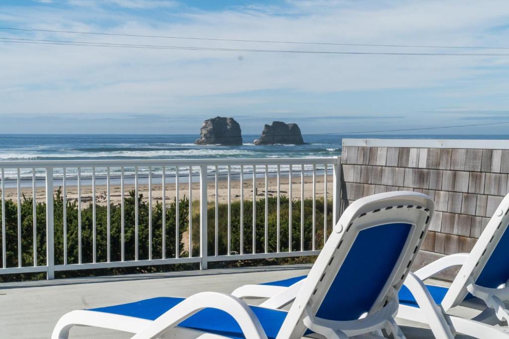 two chairs on a balcony overlooking the beach at The Strand at Twin Rocks in Rockaway Beach