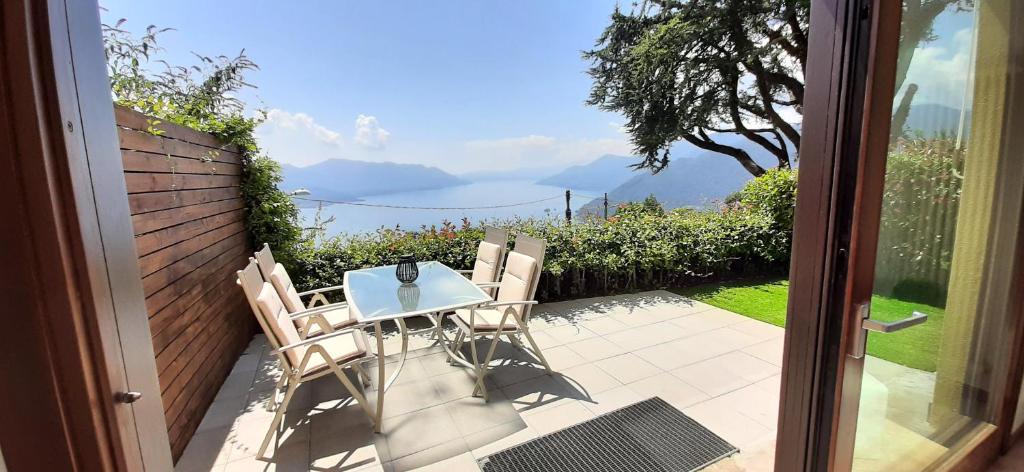 a table and chairs on a patio with a view at Appartamento Campagnano in Maccagno Superiore