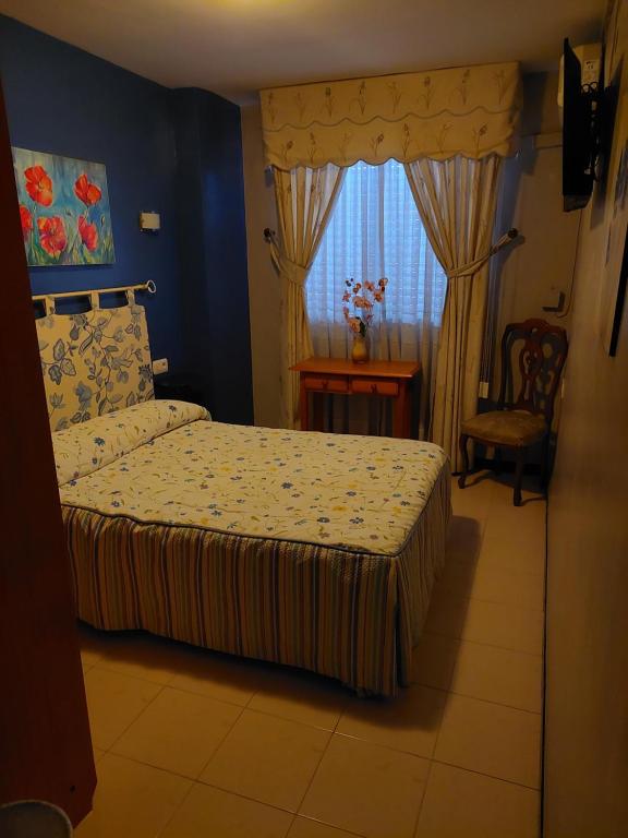 1 dormitorio con cama y ventana en Pensión Colonia, en Motril