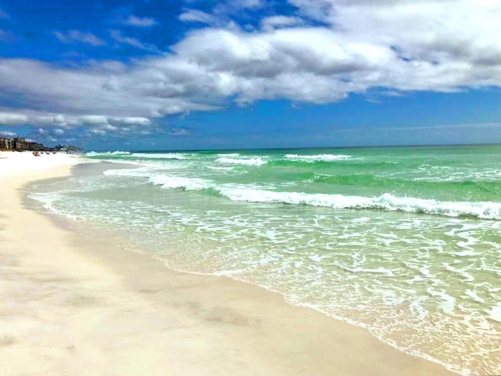 a sandy beach with the ocean and clouds in the sky at Gulf Walk 606 in Destin