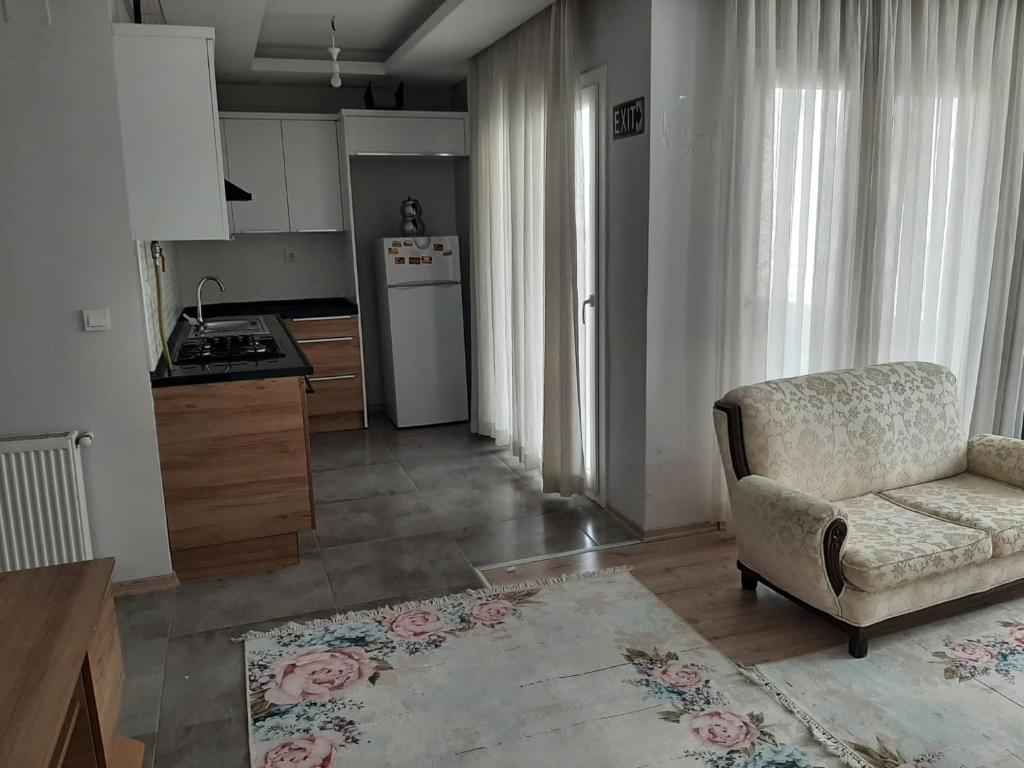 a living room with a chair and a kitchen at 2+1 RESIDENCE STADYUM in Sarıhamzalı