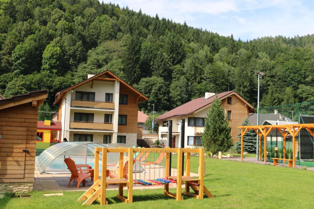 a playground in a yard with houses and trees at Wellness Simply Relax - Chopok in Tale