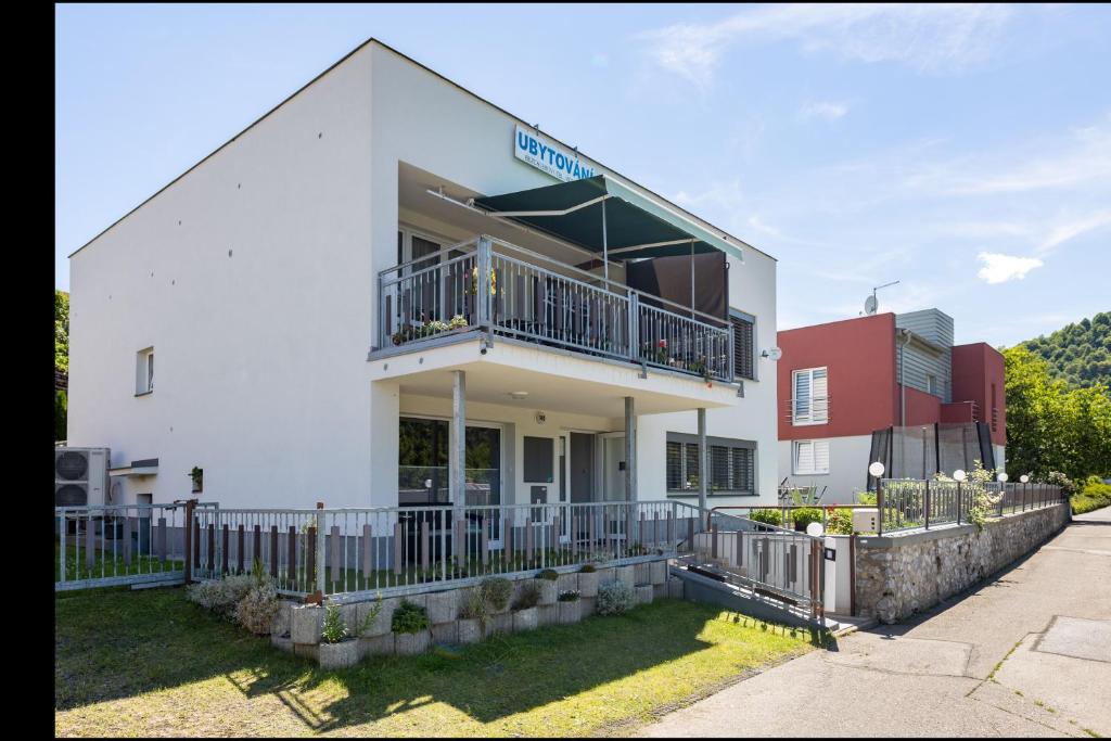 - un bâtiment blanc avec un balcon et une clôture dans l'établissement Ubytování Bezchlebovi, à Český Krumlov