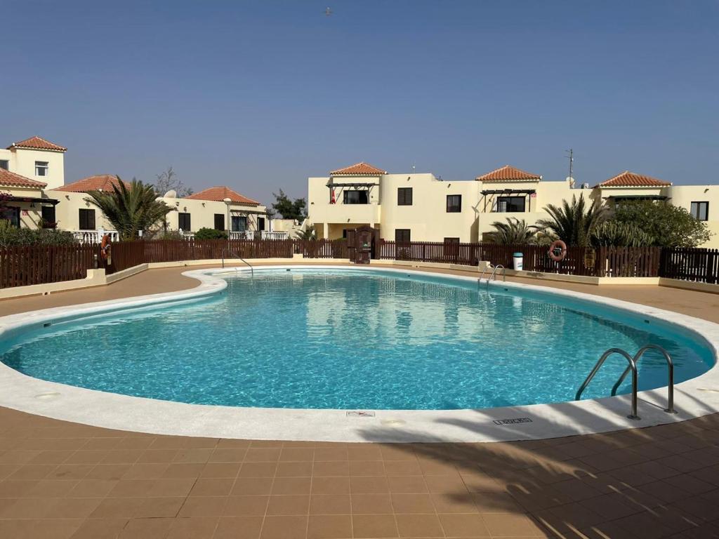 a large swimming pool in front of some houses at Teresita Deluxe with pool in Caleta De Fuste
