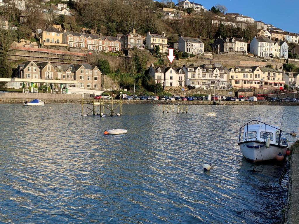 a boat is docked in the water near a city at Large House in Looe, Near Beach and Bars with Great Views, Free Parking and Free Access to a Nearby Indoor Swimming Pool in Looe