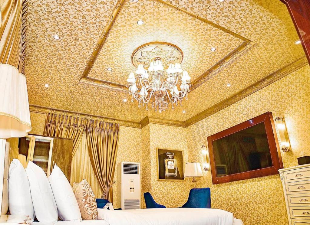 a hotel room with a chandelier and two beds at NO.1 HOTEL in Abuja