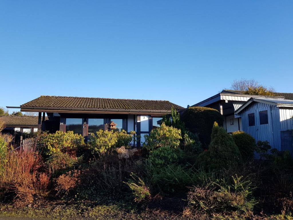 a man standing in front of a house at Holiday home on Lake Henne with terrace in Meschede