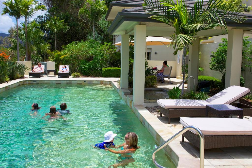 a group of children playing in a swimming pool at Portside Whitsunday Luxury Holiday Apartments in Airlie Beach