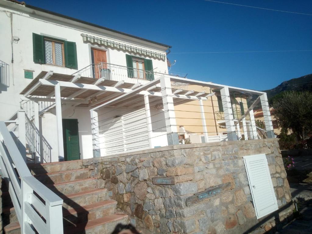a house with a stone staircase leading up to it at Appartamento orlando vista panoramica Pomonte isola D'Elba in Pomonte