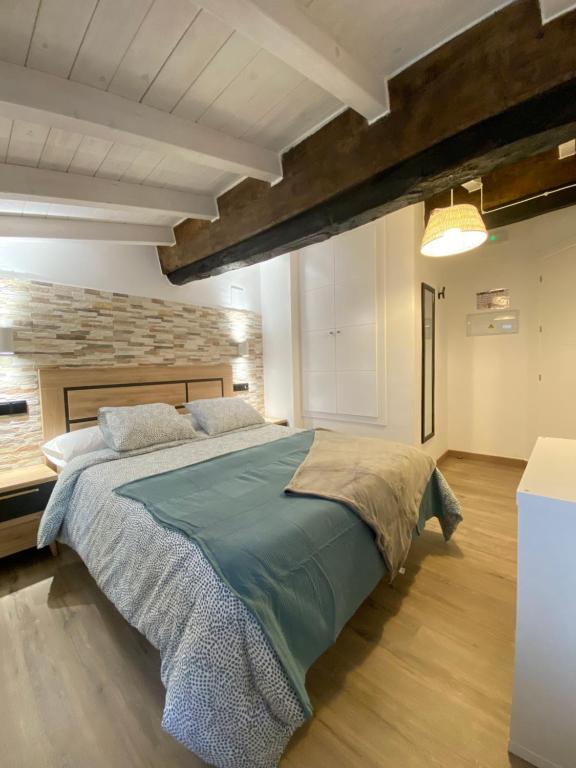 een slaapkamer met een groot bed en een stenen muur bij Apartamentos Rurales Calleabajo - 3 Estrellas in Hervás