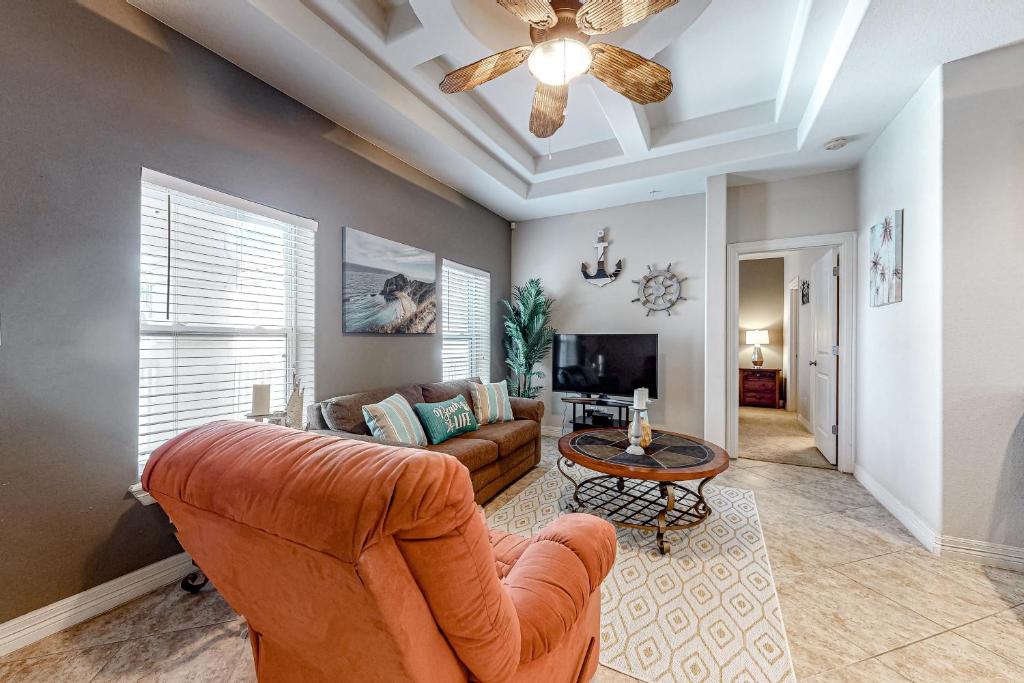 a living room with a couch and a ceiling fan at Sea Glass Condominiums #9 in South Padre Island