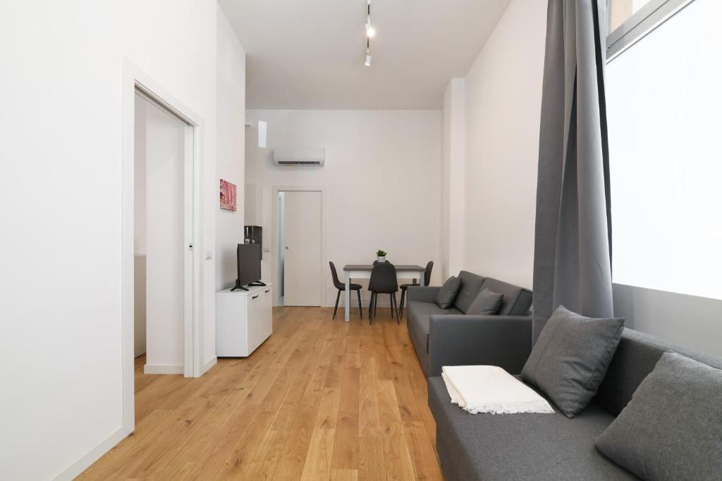 - un salon avec un canapé gris et une table dans l'établissement PrimoPiano - La Malfa flats, à Milan