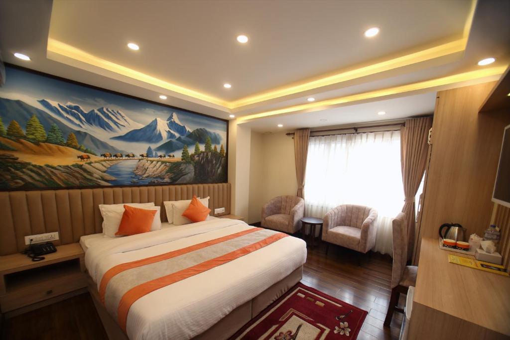 pokój hotelowy z łóżkiem i obrazem na ścianie w obiekcie Hotel Amarawati w Katmandu