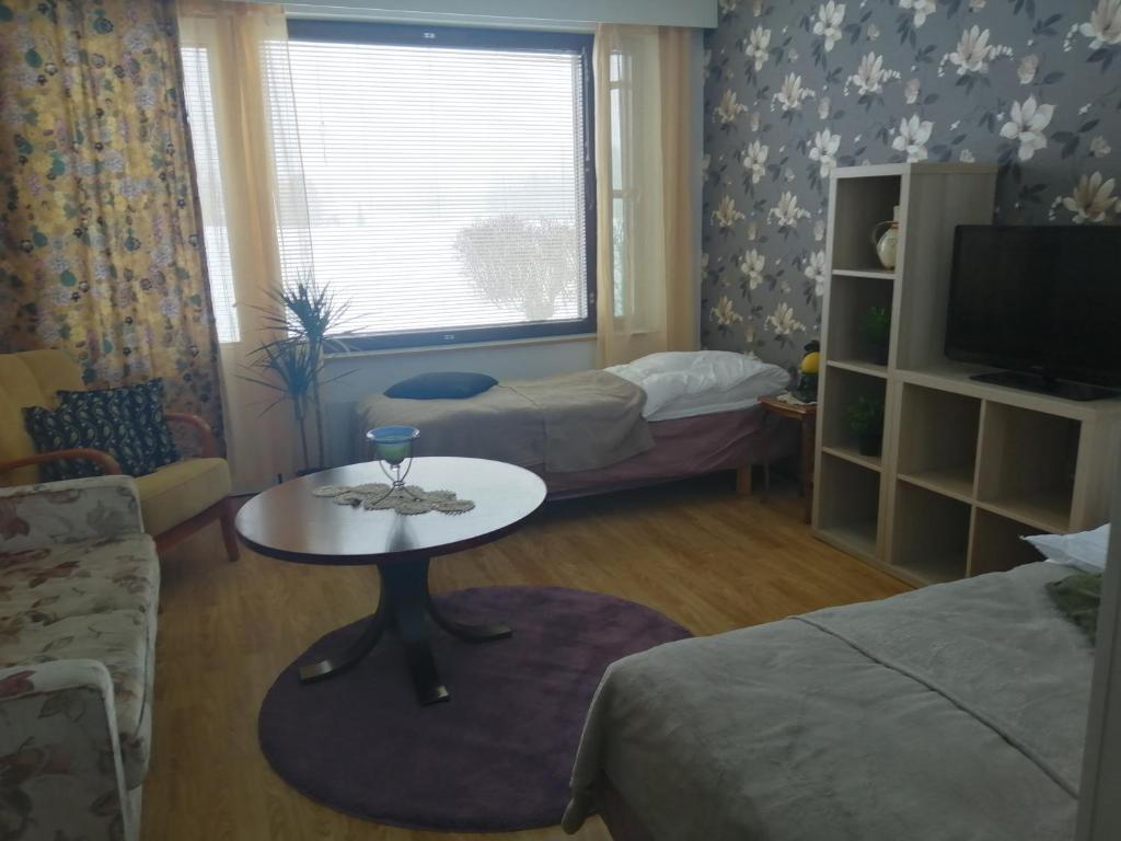 una habitación con 2 camas y una mesa con una copa de vino. en yksiö Jäppilässä, en Jäppilä